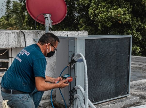 HVAC technician on a service call with jobs scheduled in BaseCloud CRM